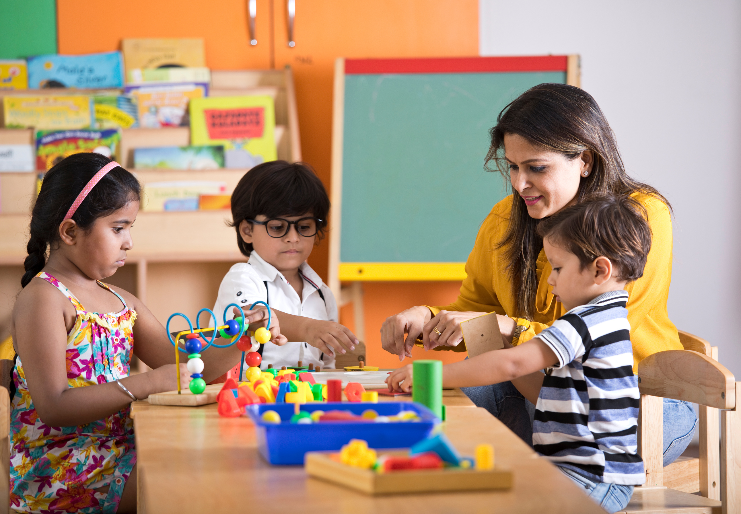 Teachers with children learning at preschool